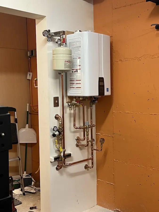 Plumbing technician inspecting water heater connections in Porters Neck